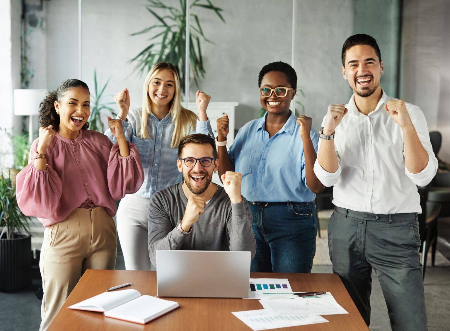 Eine Gruppe von glücklichen Mitarbeiter die durch New Work zufriedener gute Arbeitsbedingungen haben