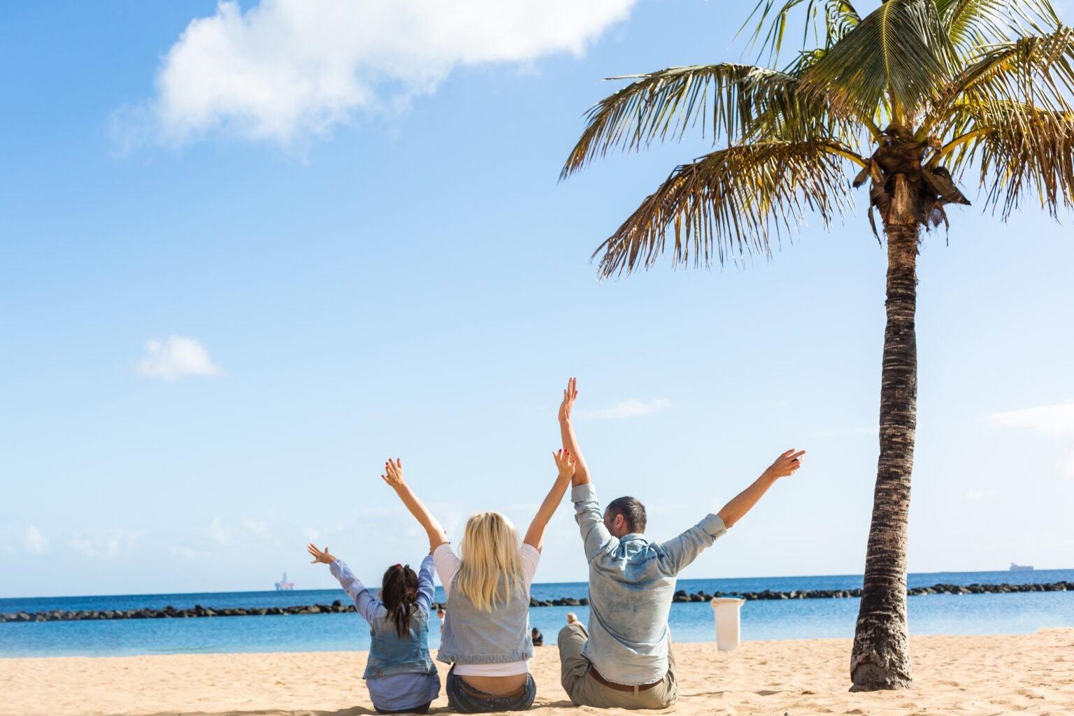Eine Familie in ihrem Sonderurlaub bei schönem Wetter am Strand