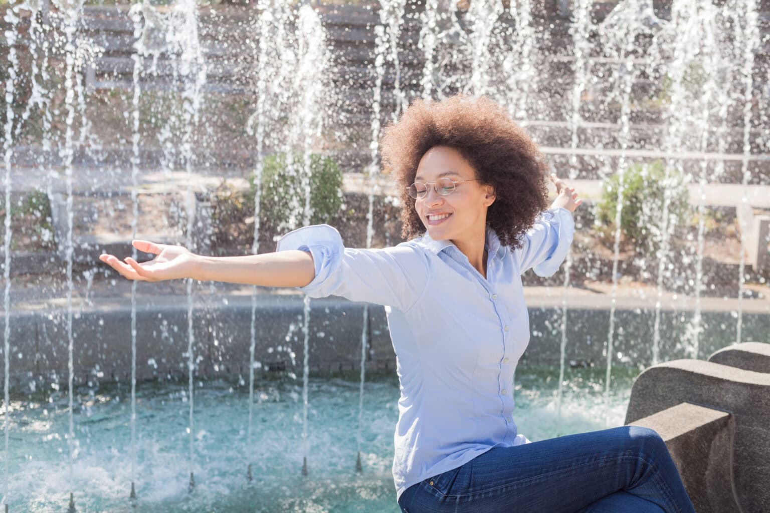 Eine Frau vor einem Brunnen mit gutem Wohlbefinden