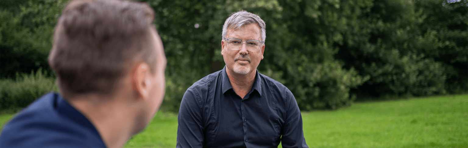 Erfahrener Mitarbeiter empfiehlt jüngeren eine betriebliche Altersvorsorge.