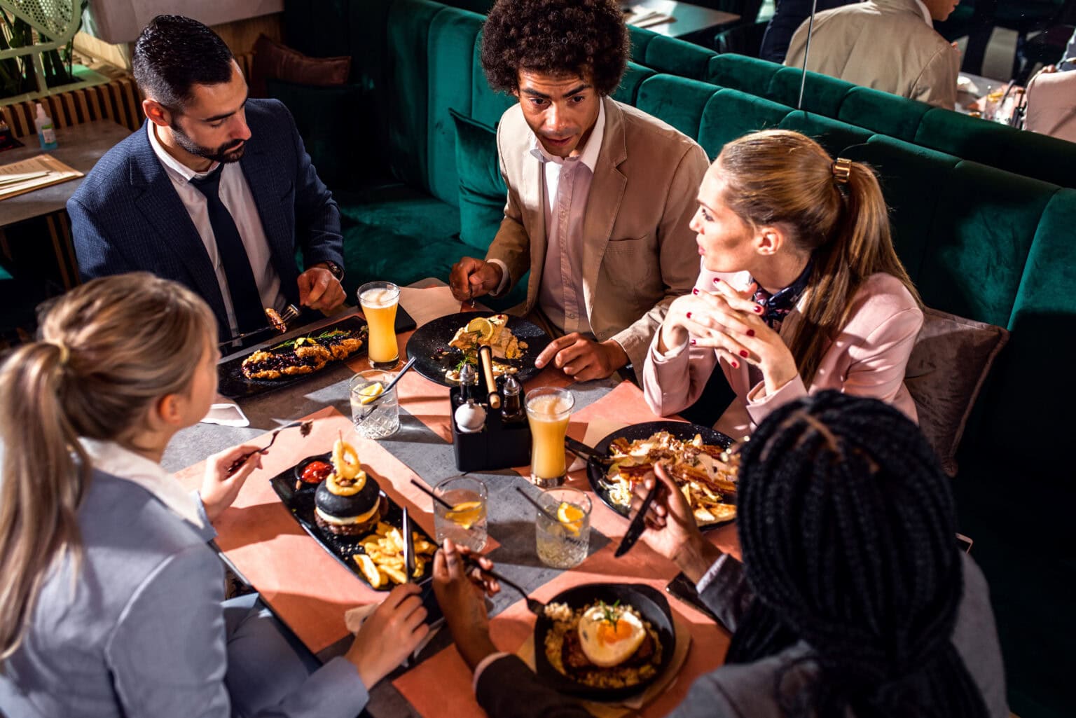 Gruppe von Geschäftsleuten im Restaurant beim Mittagessen mit Essensgutscheinen.