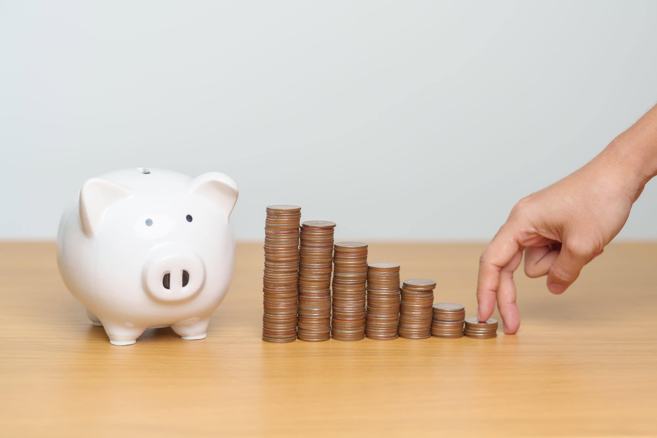 Ein Sparschwein auf dem Tisch, mit Münzen davor, die den geldwerten Vorteil symbolisieren.
