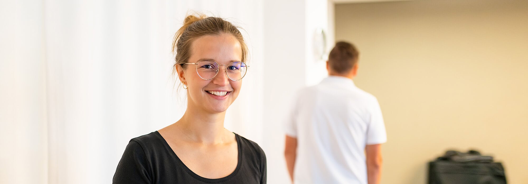 Junge Frau schaut zufrieden nach einem Präventionskurs bei der Gesundheitsförderung als Gesundheitsbonus durch den Arbeitgeber.