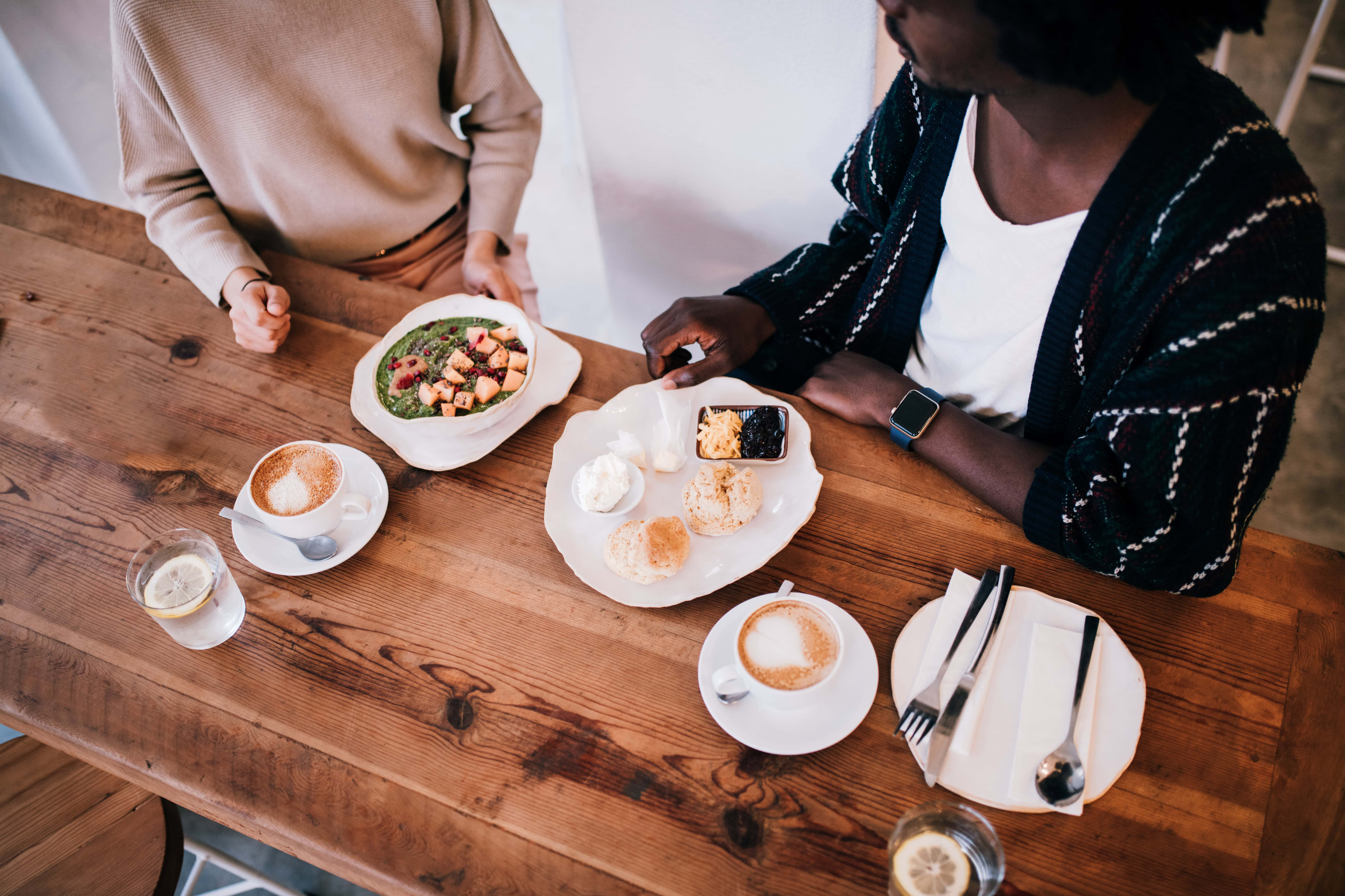 Zwei Mitarbeitende genießen gemeinsam eine Mahlzeit am Tisch, nachdem sie ihre Speisen mithilfe der Essensmarken zu einem vergünstigten Preis erworben haben.